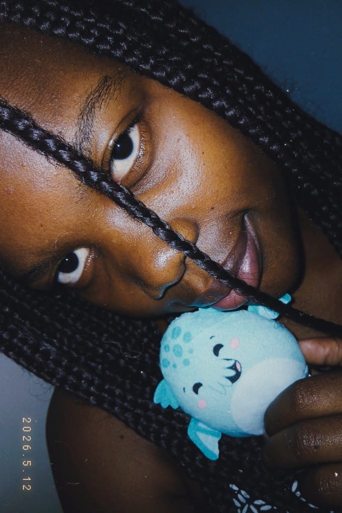 Percia de perto, com um peluche pequeno junto ao rosto